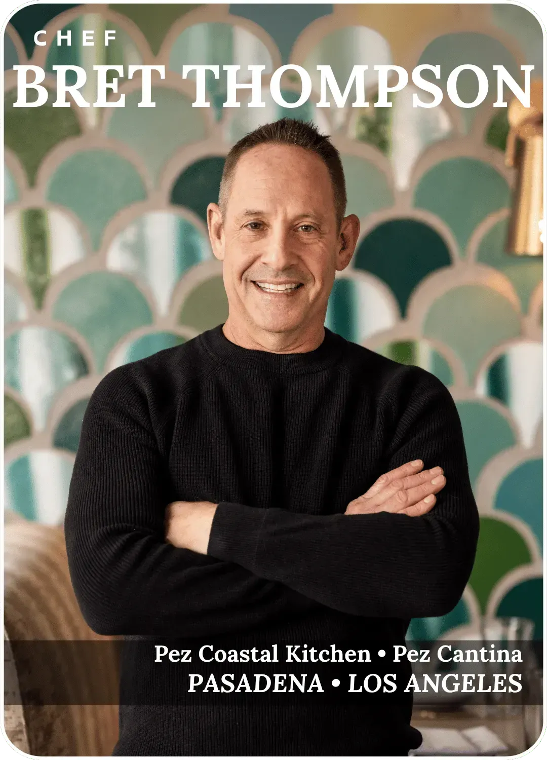 Chef Bret Thompson smiling with arms crossed, in front of teal arches
