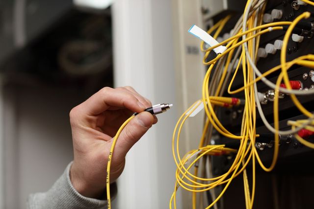 A person is holding a yellow cable in their hand.