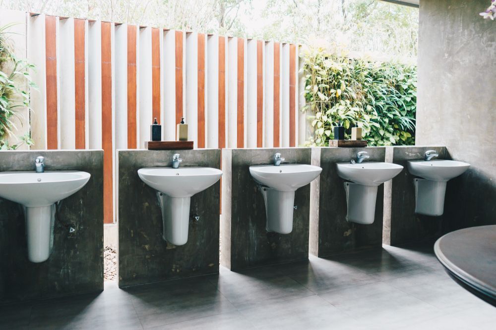 A Row of White Sinks Are Lined Up in a Bathroom — MacKenzie Plumbing In West Mackay, QLD