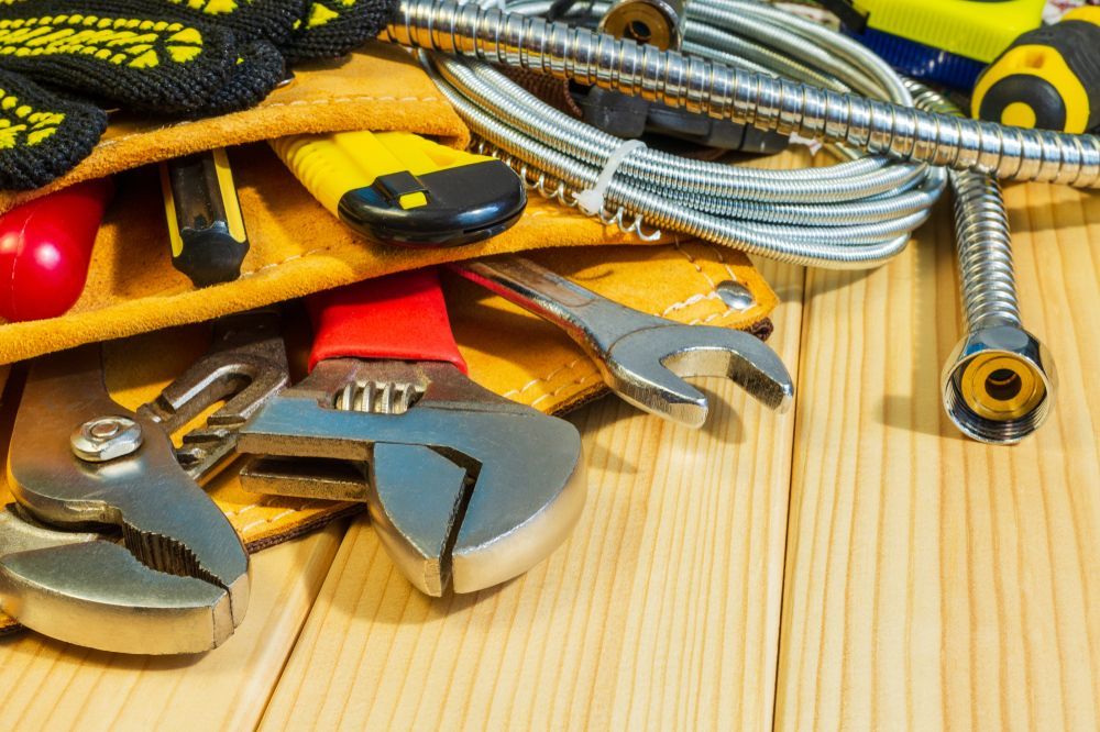 A Bunch of Tools Are Sitting on a Wooden Table — MacKenzie Plumbing In Walkerston, QLD