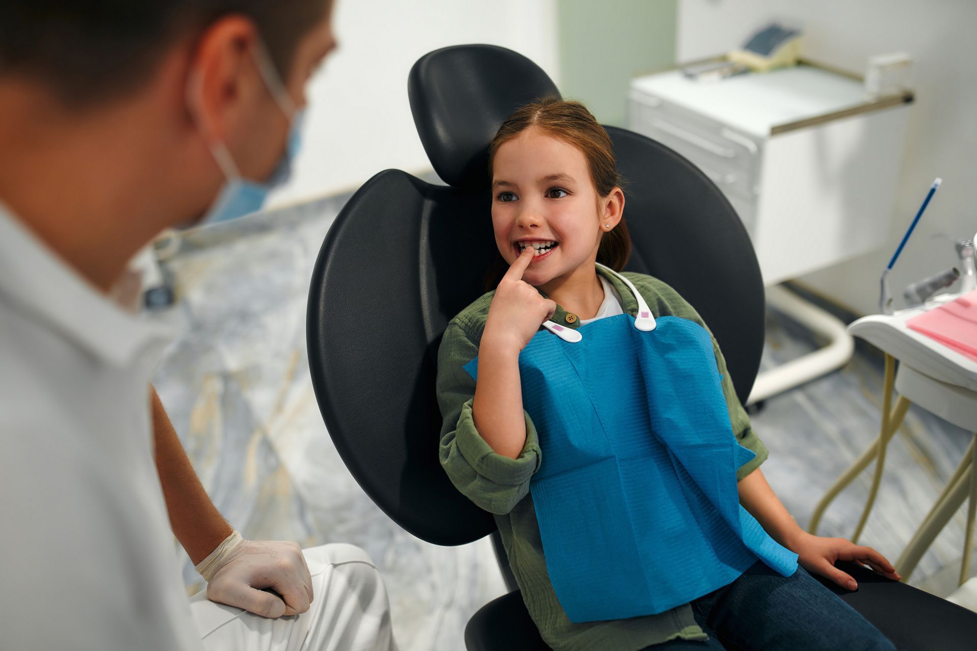 Comprehensive care from a hospital dentist in East Norriton, PA. A little girl is sitting in a dental chair with a dentist.