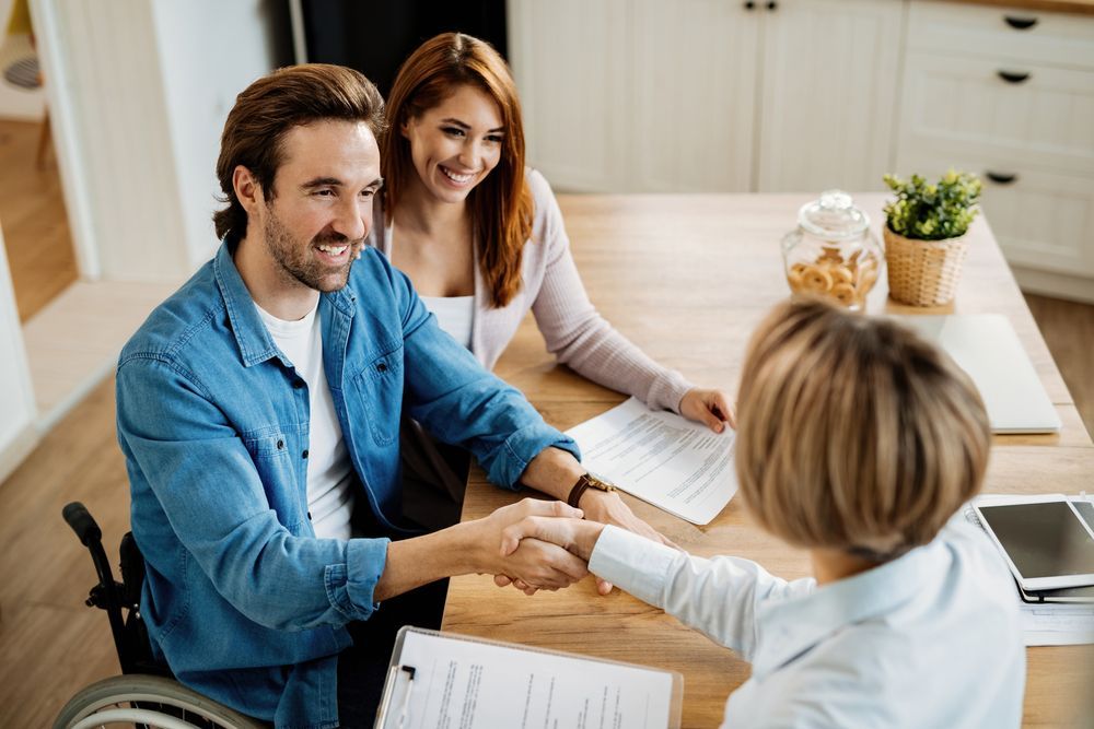Man in Wheelchair Shakes Hands With a Person and Woman Smiles — Accountsloop Tax & Business Advisory in Geelong, VIC