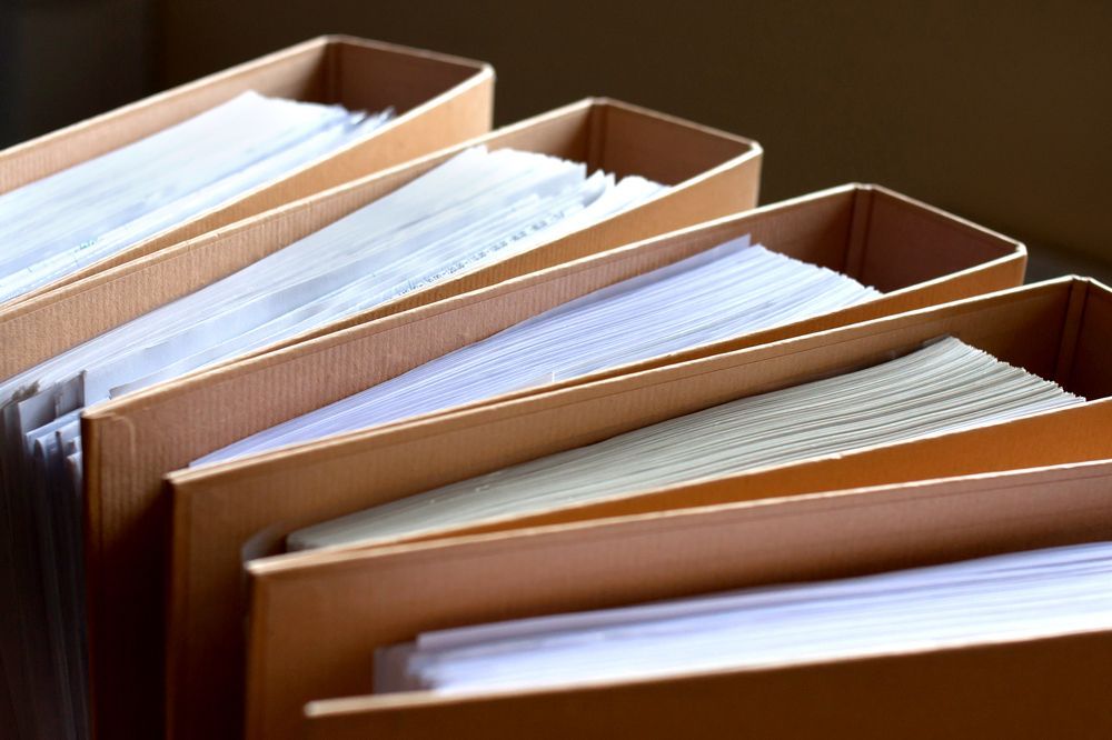 Four Open Tan File Folders Filled With White Paper — Accountsloop Tax & Business Advisory in Geelong, VIC