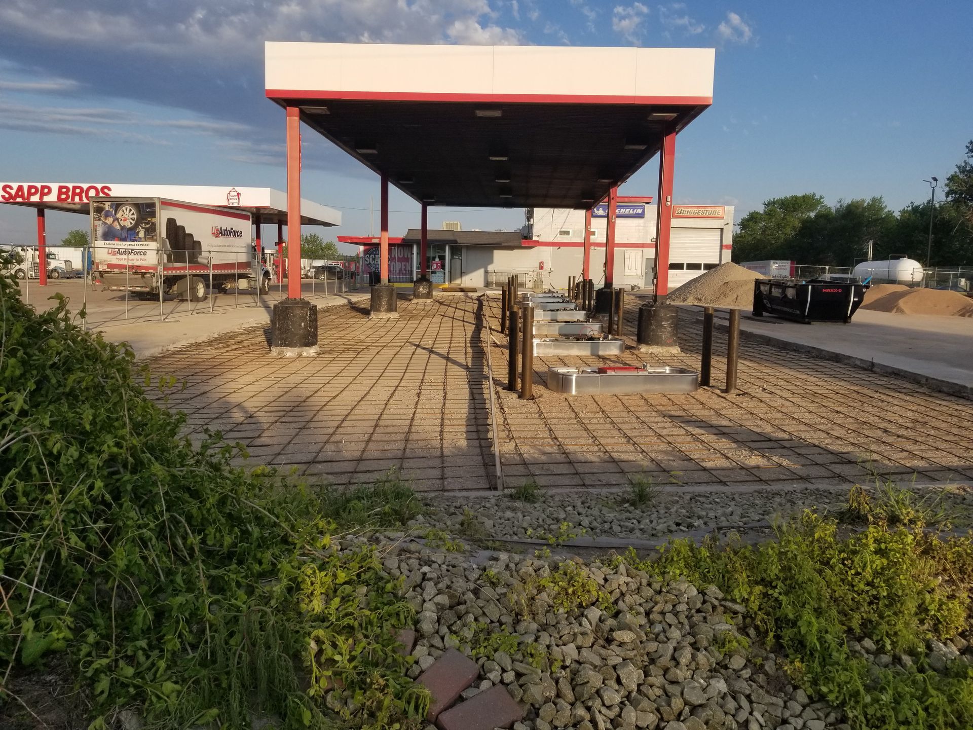 Abandoned gas station canopy and pumps beside a paved road under a clear sky