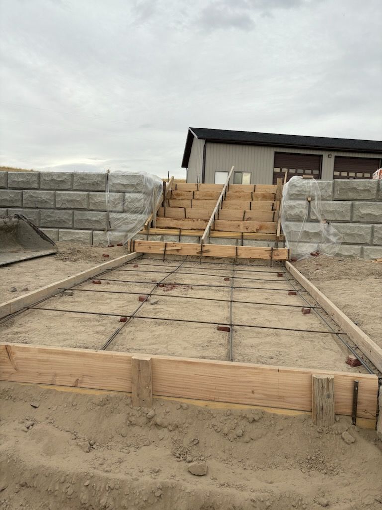 Concrete staircase under construction between retaining walls at a residential site