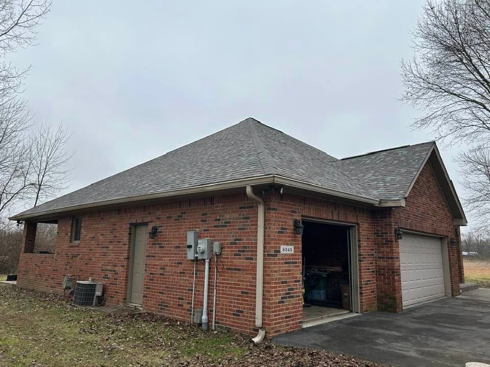 Brick house with attached garage and open side door on a cloudy day