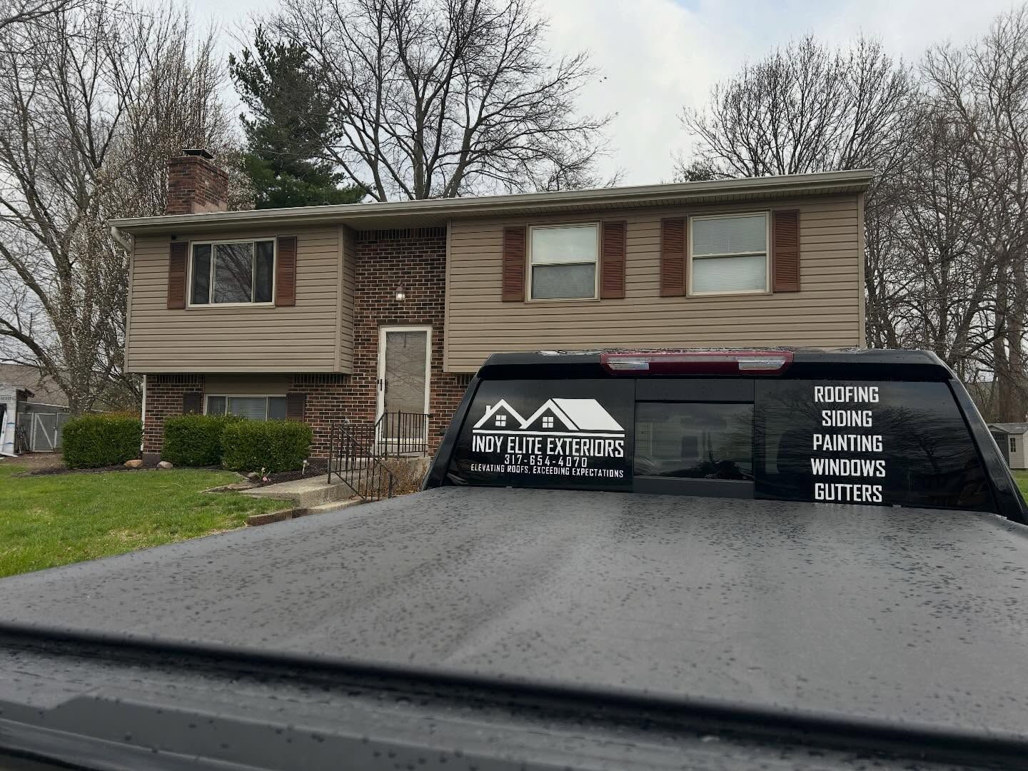 Suburban house with a black vehicle parked in front that says 
