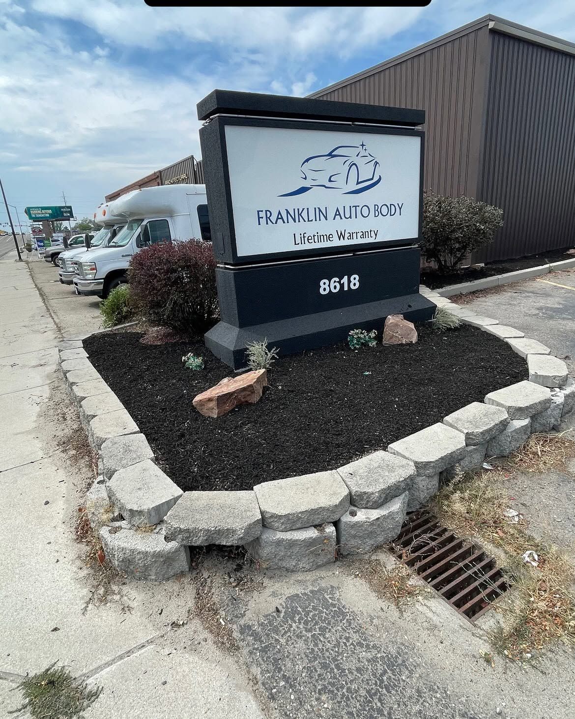 Outdoor sign for Franklin Alloy, beside a gravel lot and stone border