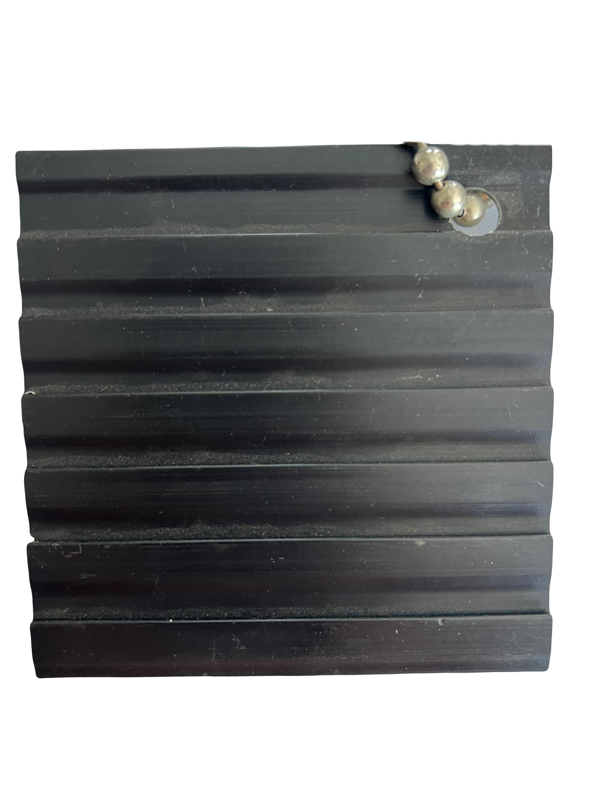 A pair of earrings are sitting on top of a black rubber mat.