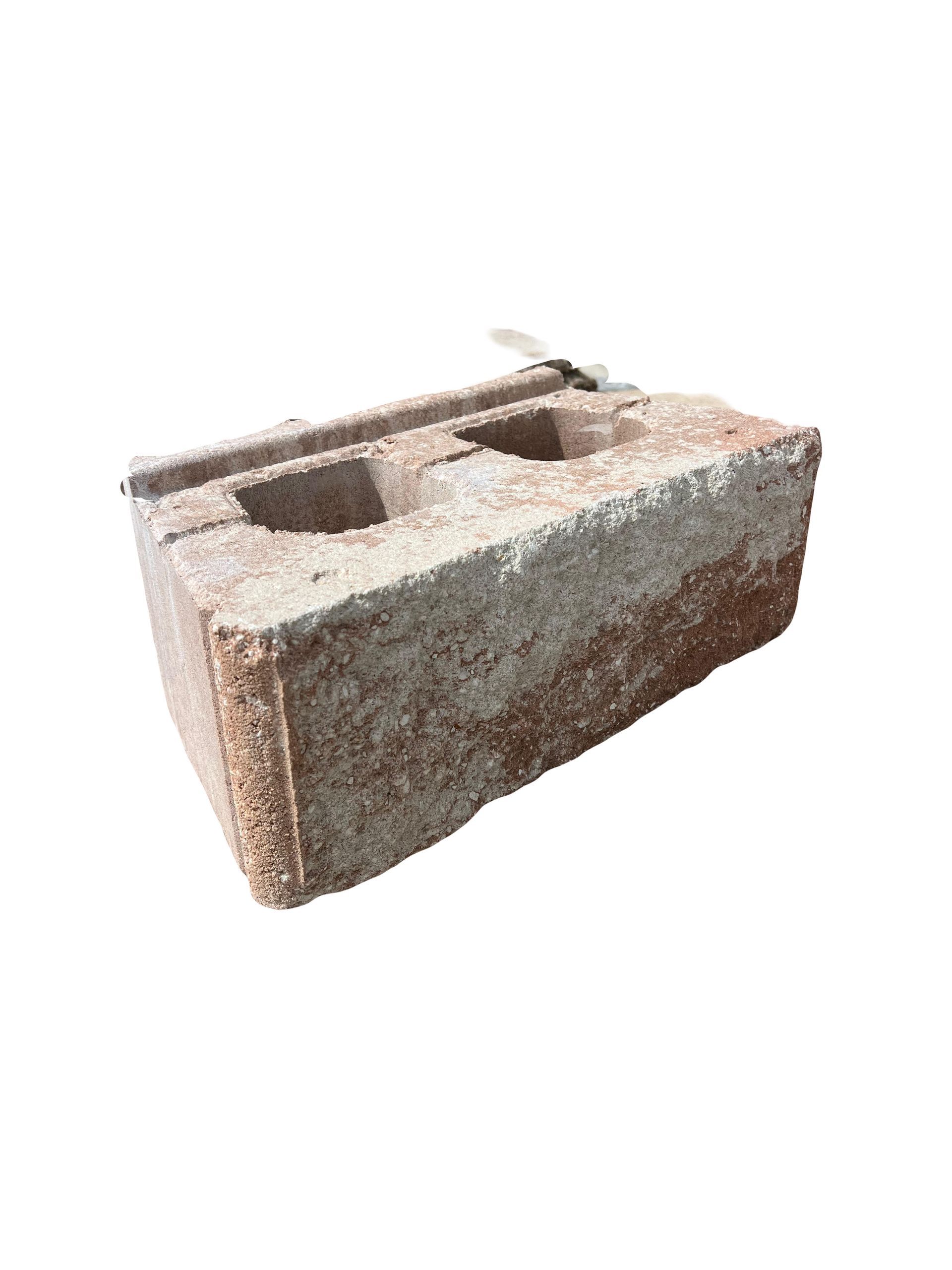 A brick with two holes in it on a white background.