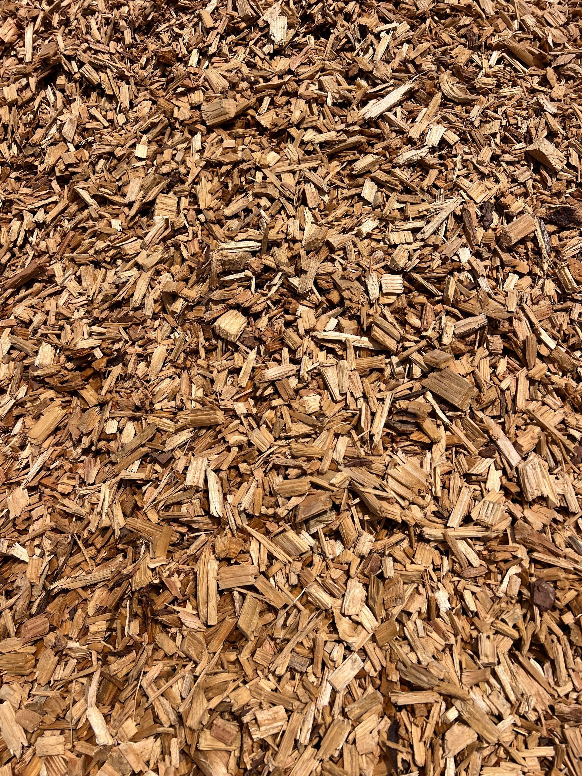 A pile of wood chips is sitting on the ground.