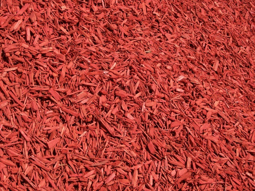 A pile of red mulch is sitting on the ground.