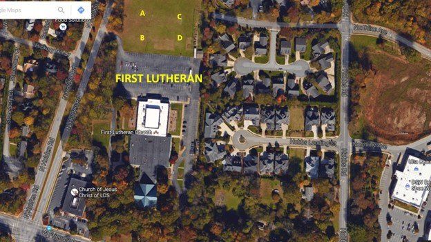 Aerial view of a church complex labeled “FIRST LUTHERAN” with parking lots and surrounding buildings.