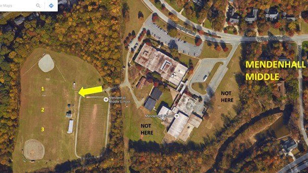 Aerial view of baseball fields and school buildings labeled “Mendenhall Middle,” with a yellow arrow pointing left.