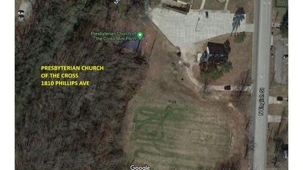 Aerial view of a church labeled “Presbyterian Church of the USA” beside fields and a road.