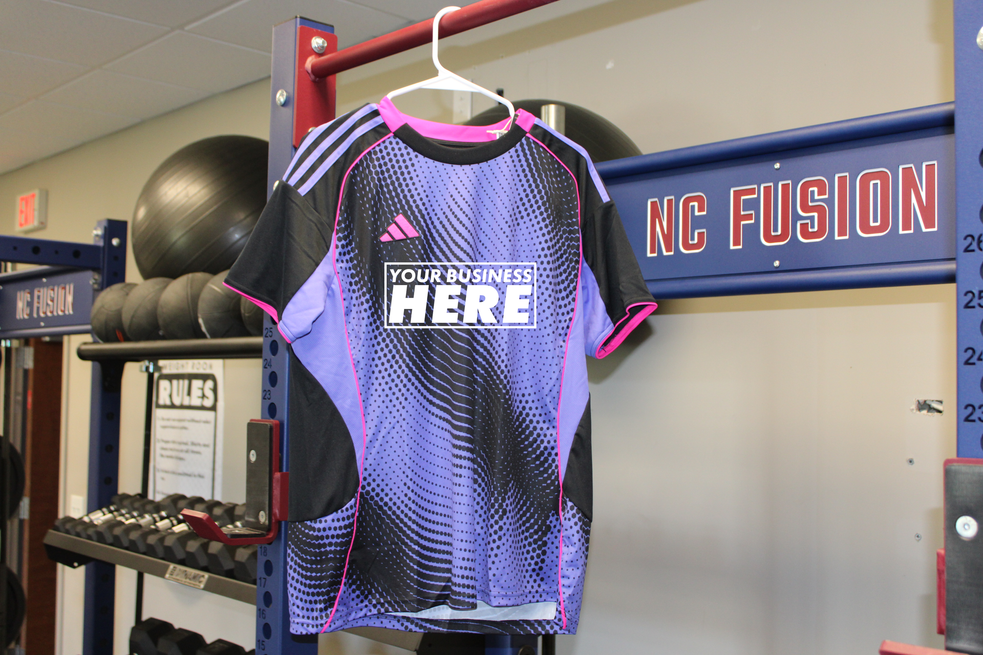 Purple and black sports jersey hanging in a store, with “NC FUSION” sign in the background