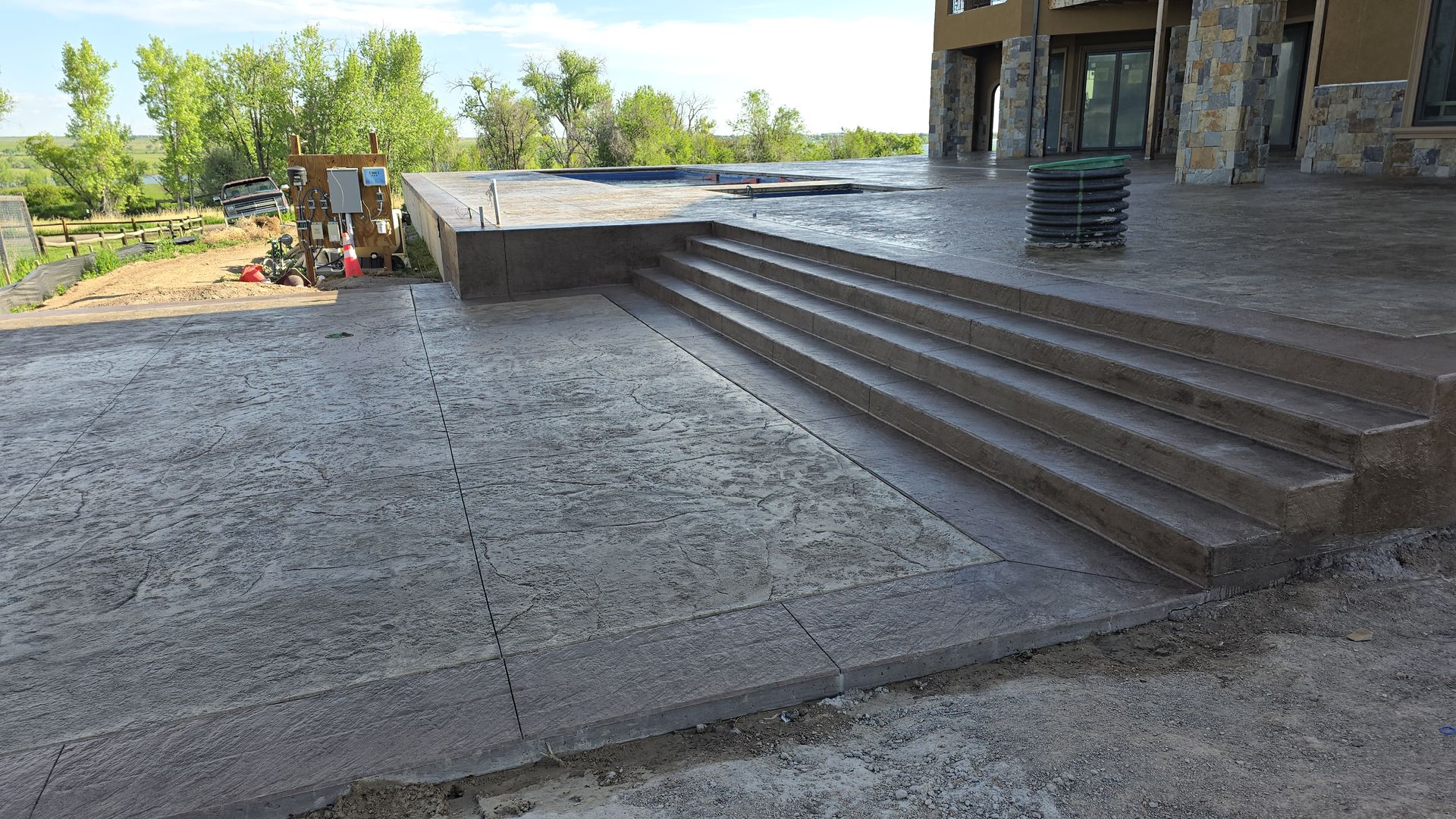 A man in an orange vest is walking down a concrete walkway.
