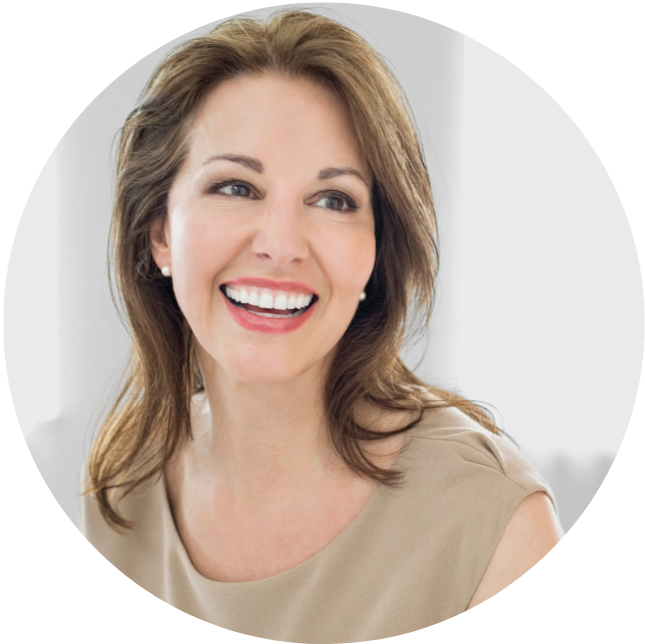Smiling woman with brown hair in a beige top against a light background