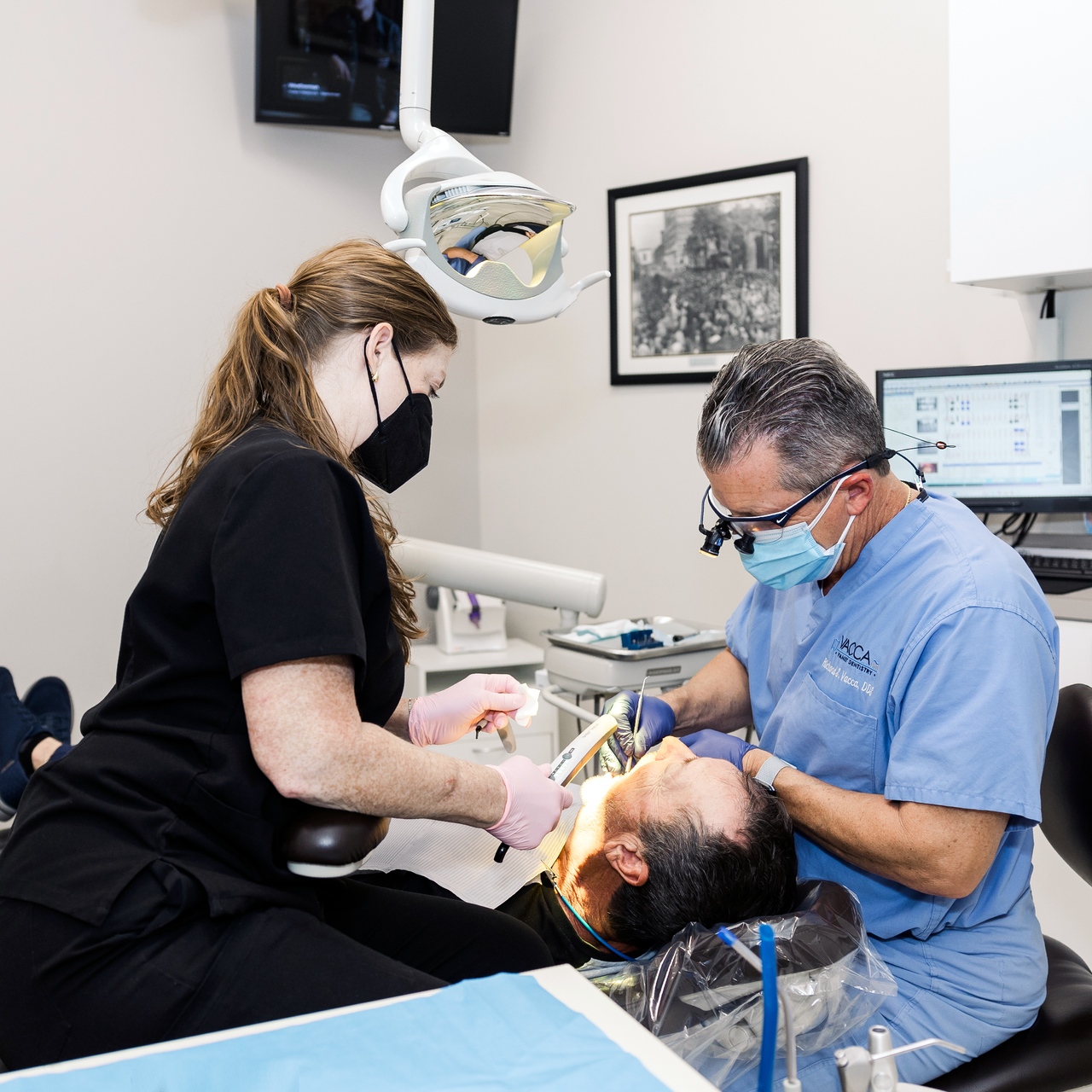 Dentist and assistant treating a patient in a dental clinic