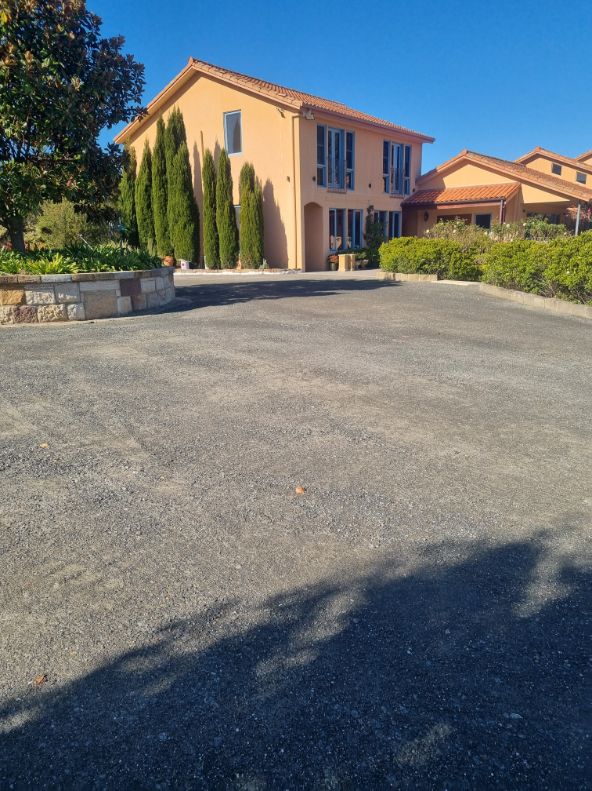 A Concrete Driveway with A house in the back of image — Hunter Valley Bitumen In Maitland, NSW
