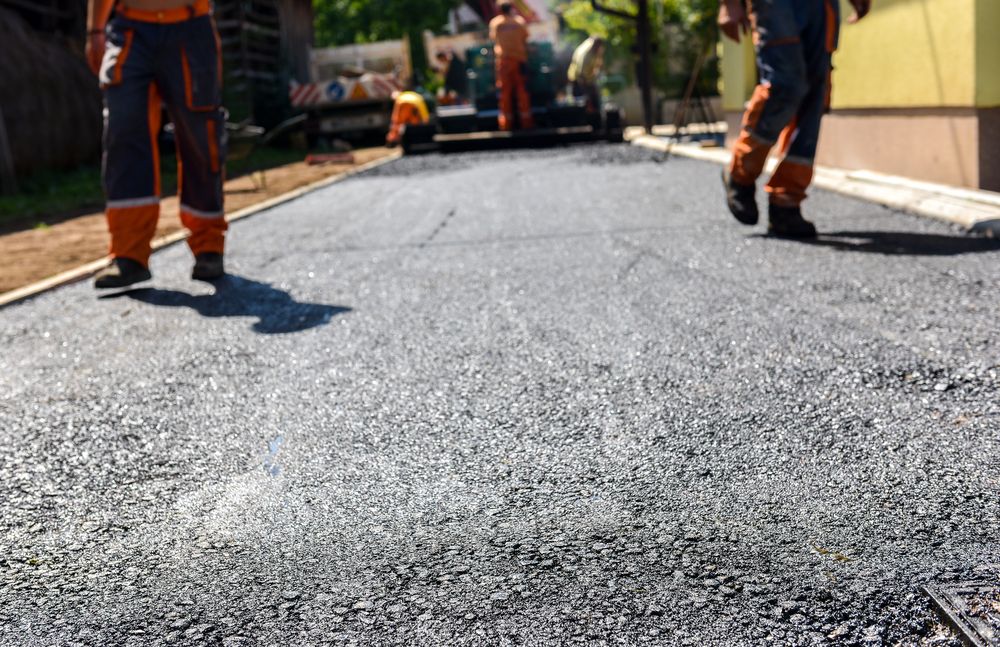 A Group of Construction Workers Are Walking Down a Road — Hunter Valley Bitumen In Hunter Valley, NSW