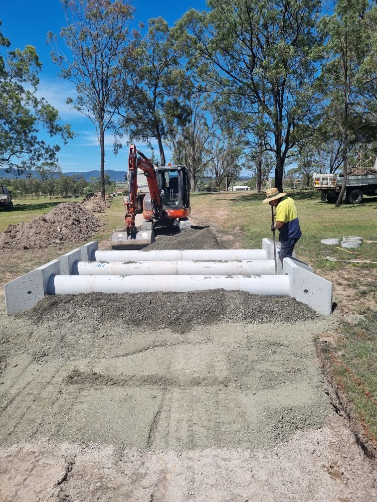 Construction of Concrete Culvert Pipes With Excavator and Worker — Hunter Valley Bitumen in Gresford, NSW
