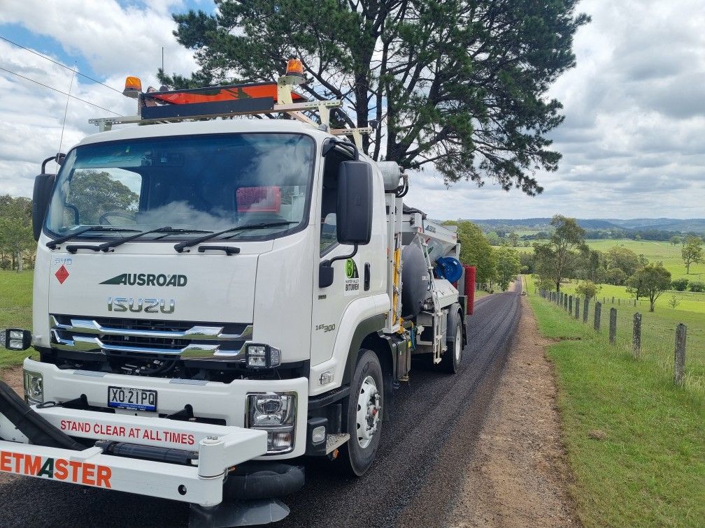 Bitumen sealing truck on a freshly surfaced rural road – Hunter Valley Bitumen in Gresford, NSW.