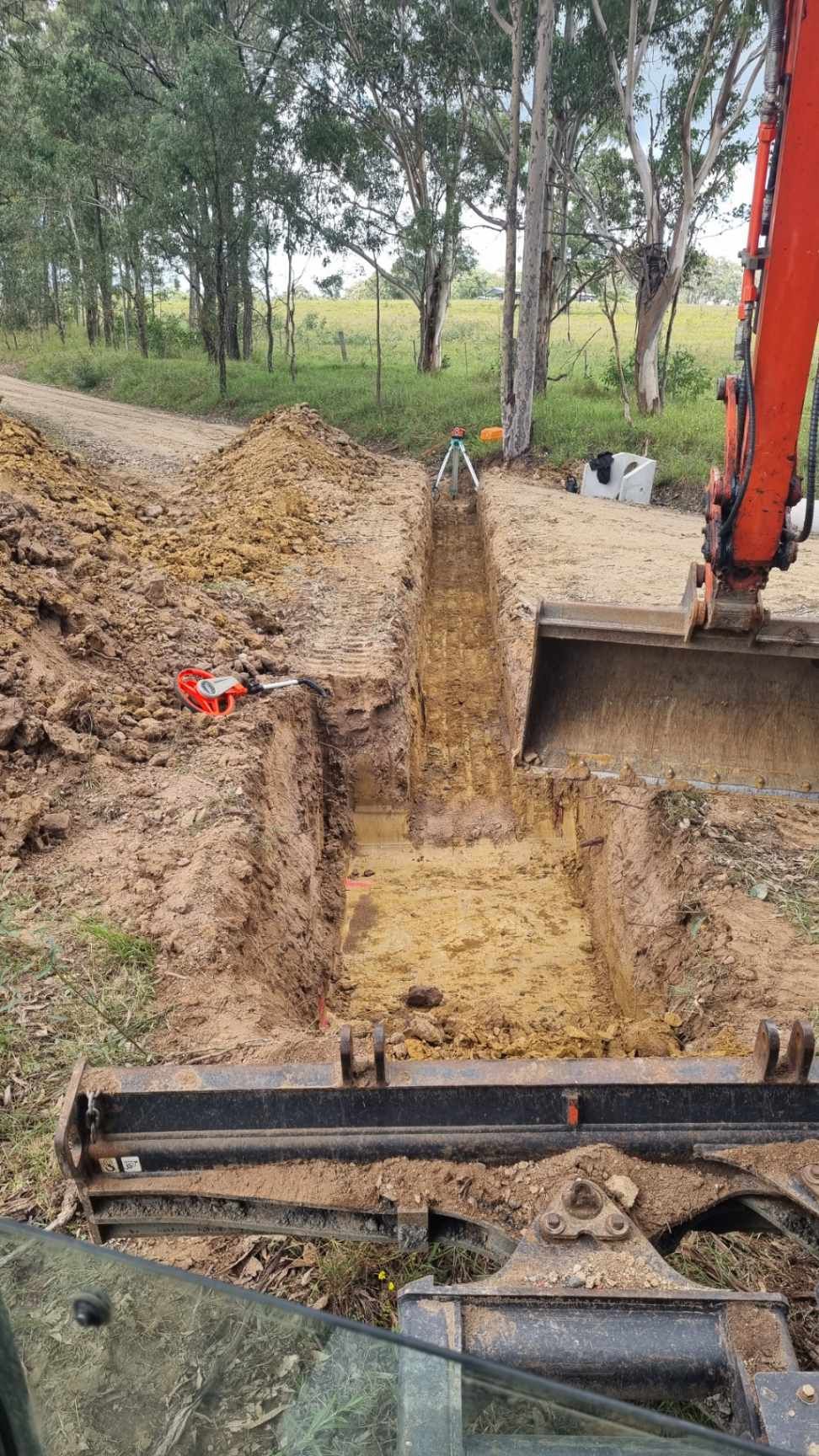 Excavator Digging a Long Trench in a Rural Dirt Road Area — Hunter Valley Bitumen in Gresford, NSW