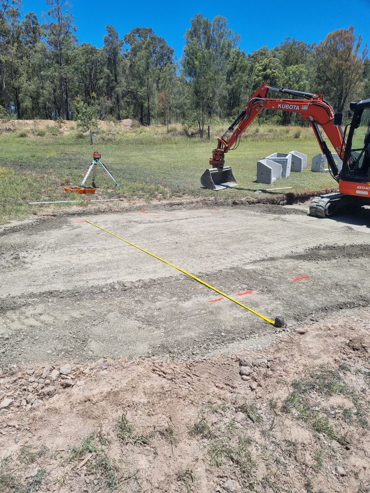 Levelled gravel area with measuring tape and excavator on site.— Hunter Valley Bitumen In Gresford, NSW
