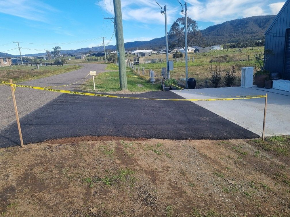 Freshly paved driveway entrance with caution tape blocking access.— Hunter Valley Bitumen In Gresford, NSW
