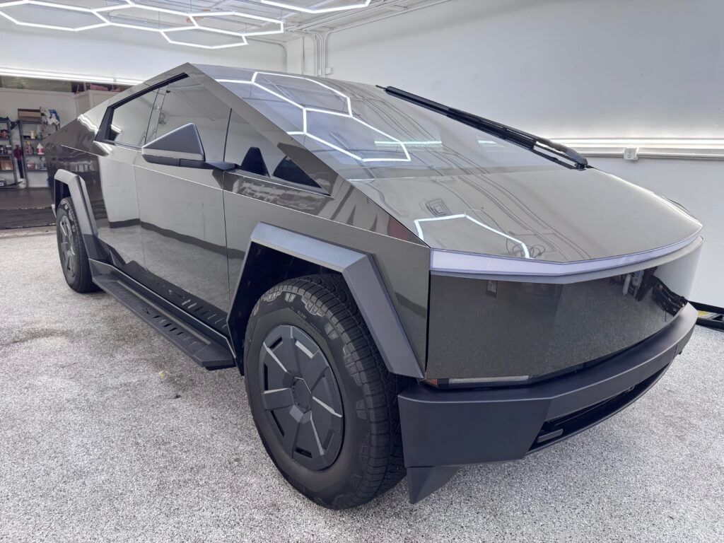 Angular silver Tesla Cybertruck parked indoors under bright ceiling lights
