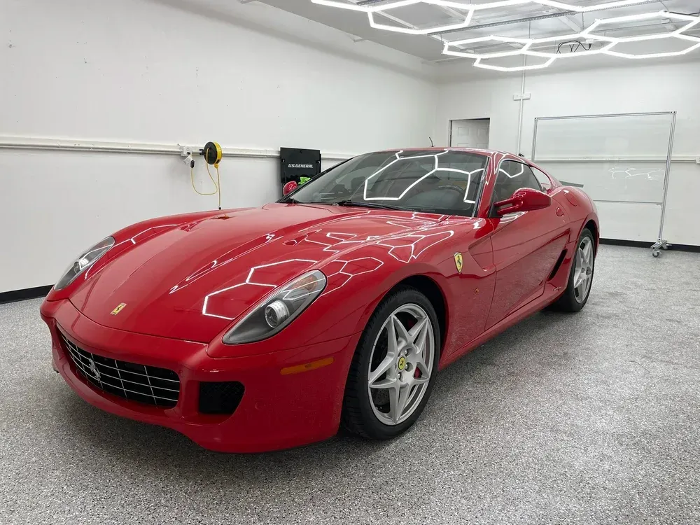 Red Ferrari sports car parked in a bright garage