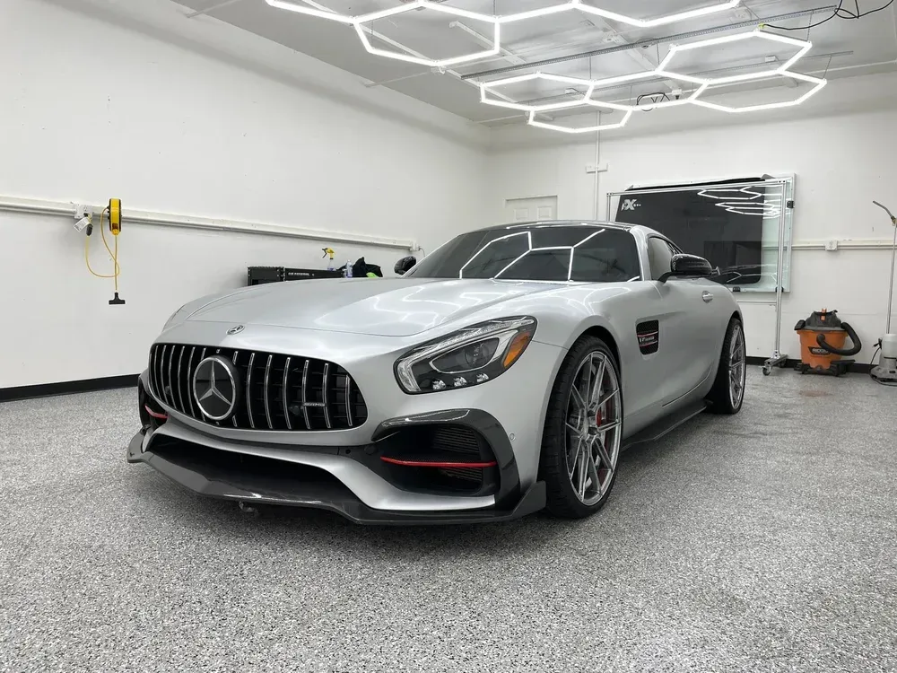 Silver Mercedes sports car in a bright garage with hexagon ceiling lights