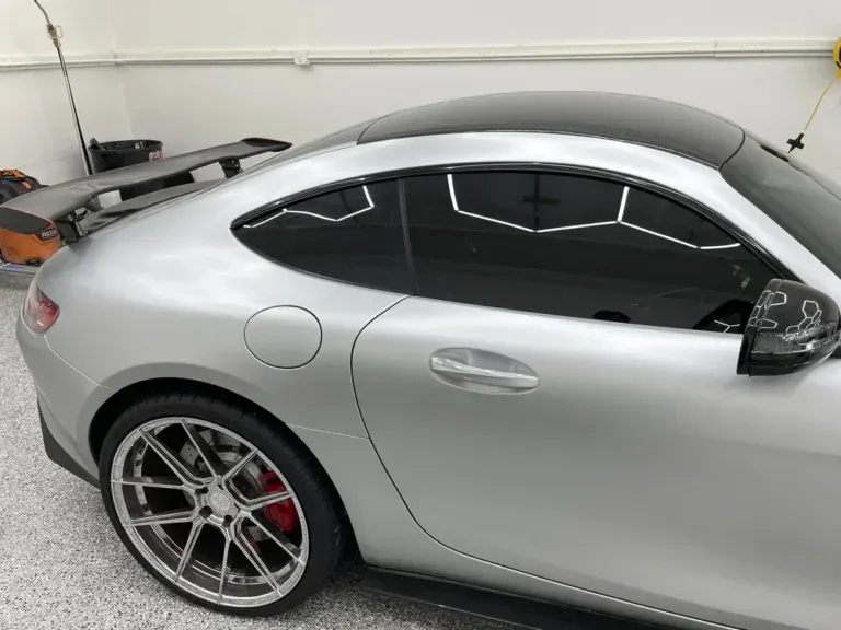 Silver sports coupe with tinted windows and alloy wheels parked in a garage