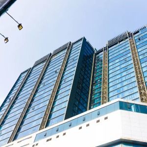 Modern glass high-rise buildings viewed from below against a blue sky