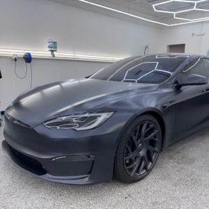 Matte gray sports car parked in a clean garage, front-left view