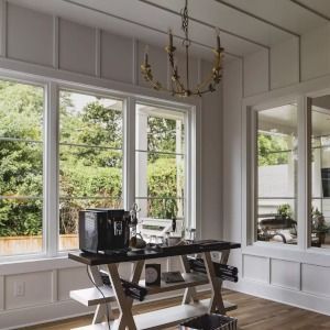 Bright dining room with large windows, a chandelier, and a small table by the view.