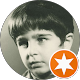 Black-and-white portrait of a child with a small orange star badge in the corner