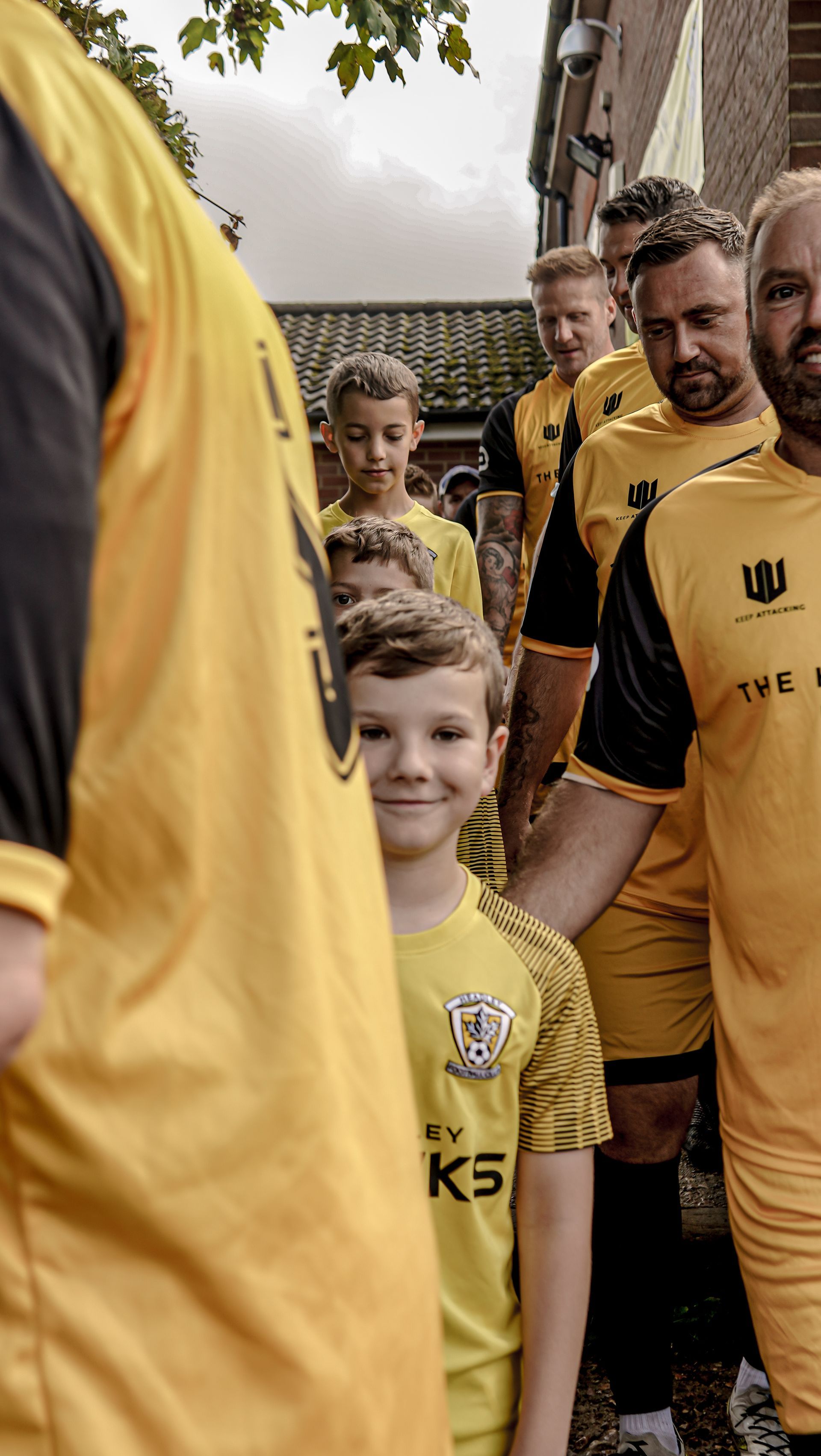 A group of people in yellow jerseys are standing next to each other.