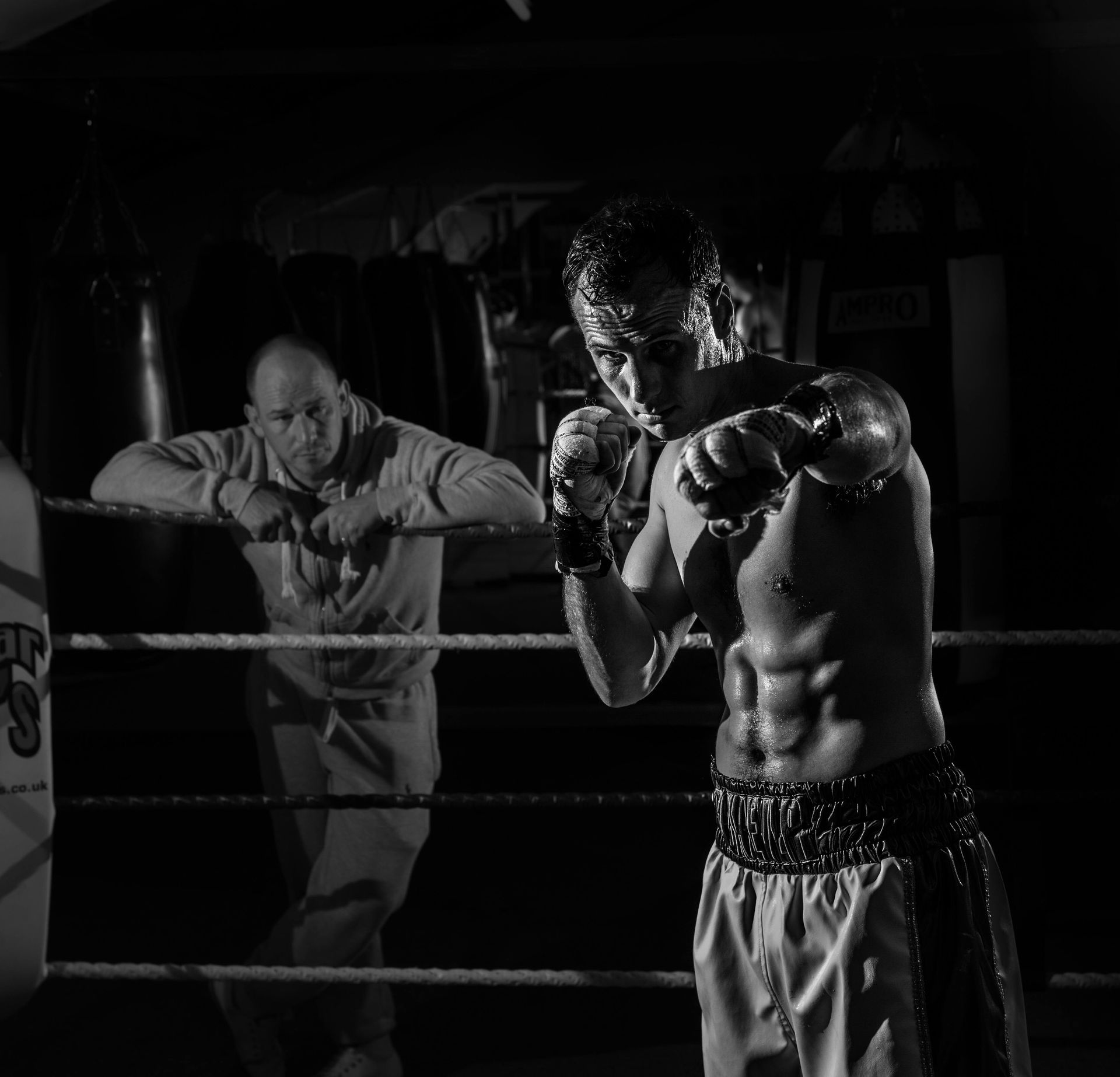 A black and white photo of two men in a boxing ring