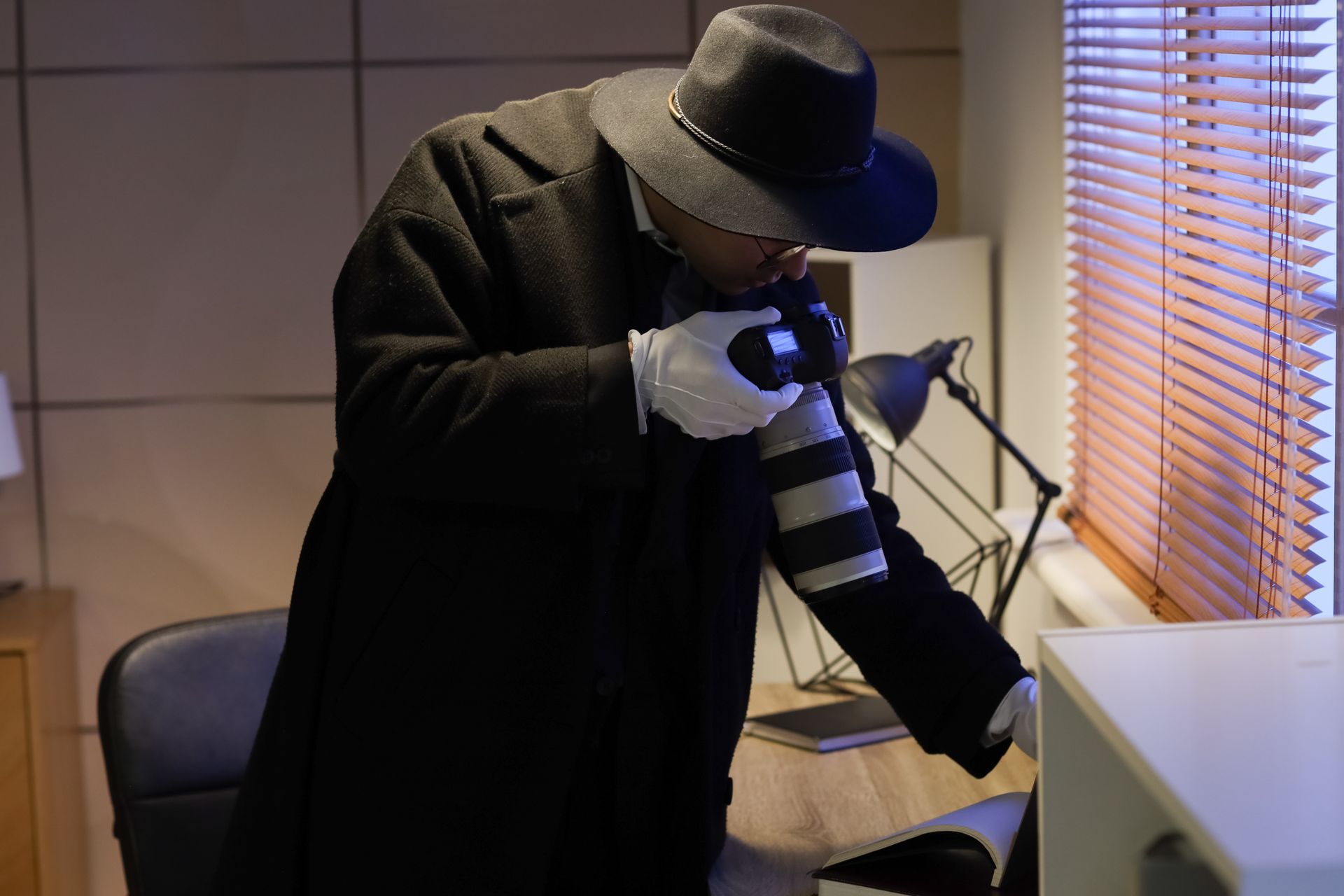 A man in a hat is taking a picture with a camera.