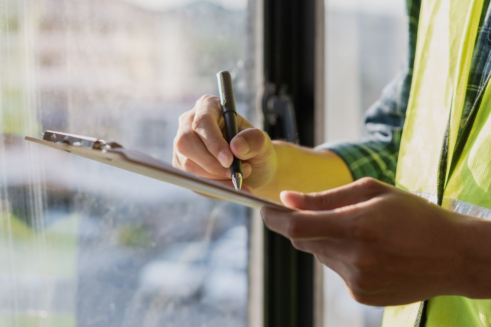A person is writing on a clipboard with a pen.