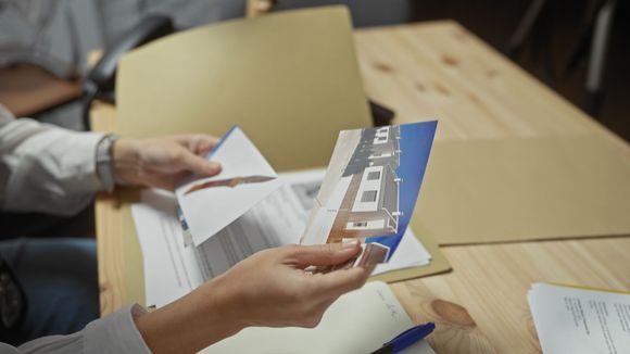 A person is holding a piece of paper in their hands.