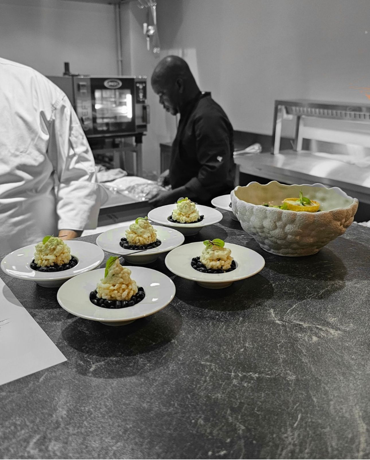 A black and white photo of a chef preparing food