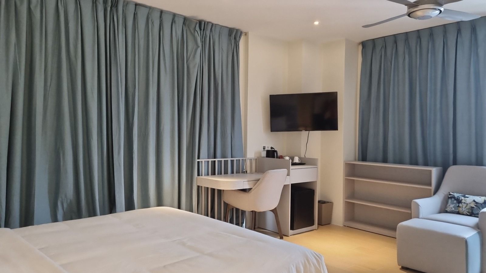 A bedroom with a bed , desk , chair and television.