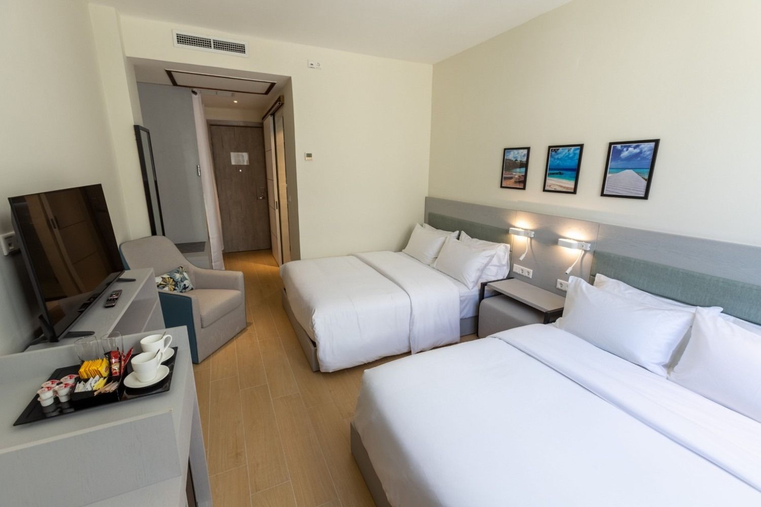 A hotel room with two beds and a television.