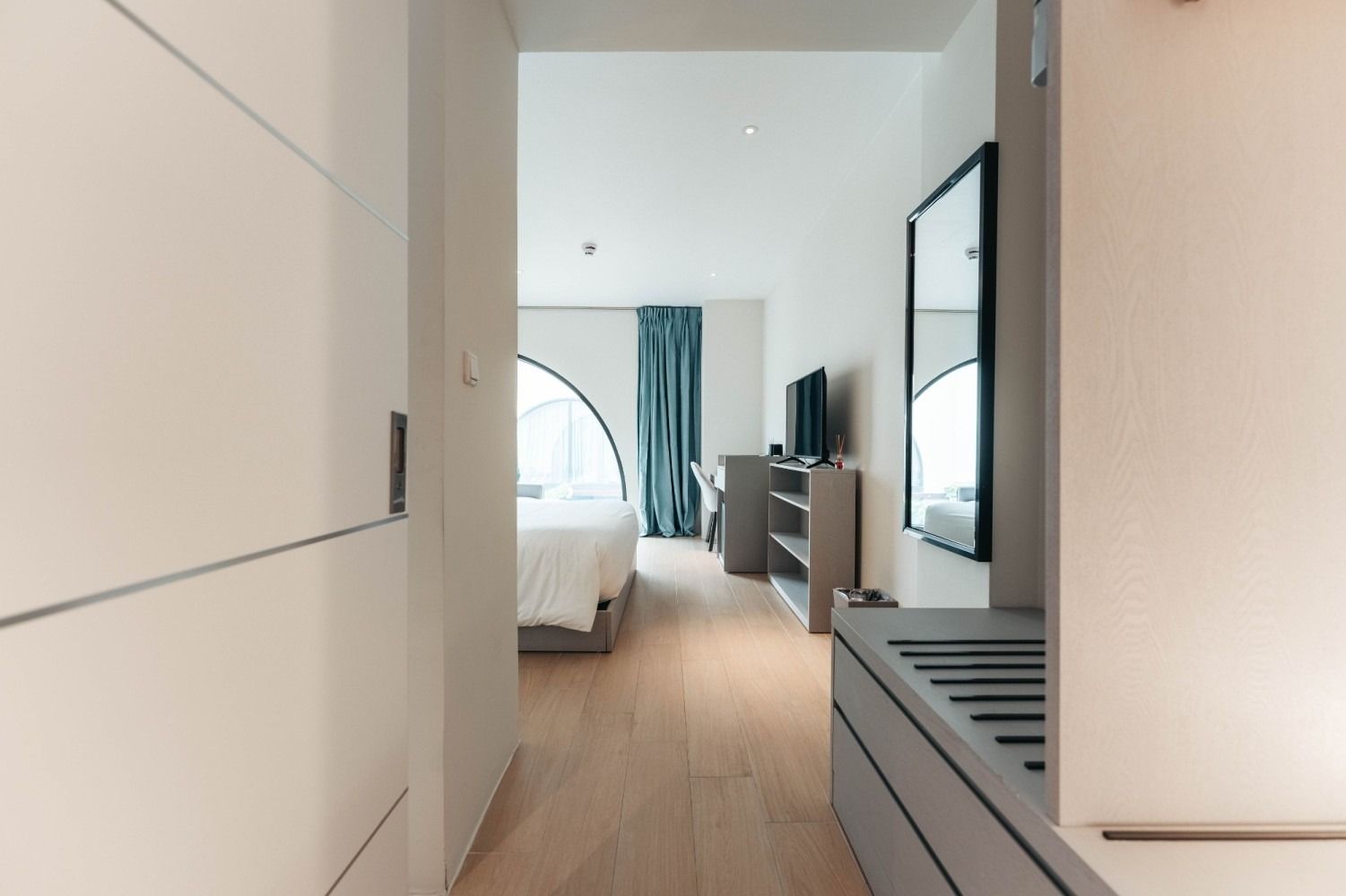 A hotel room with a bed and a television