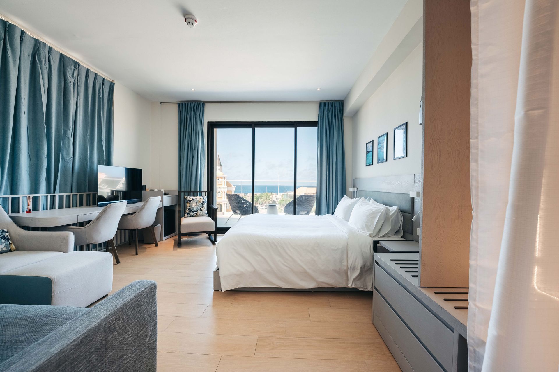 A hotel room with a large bed , couch , desk and chairs.
