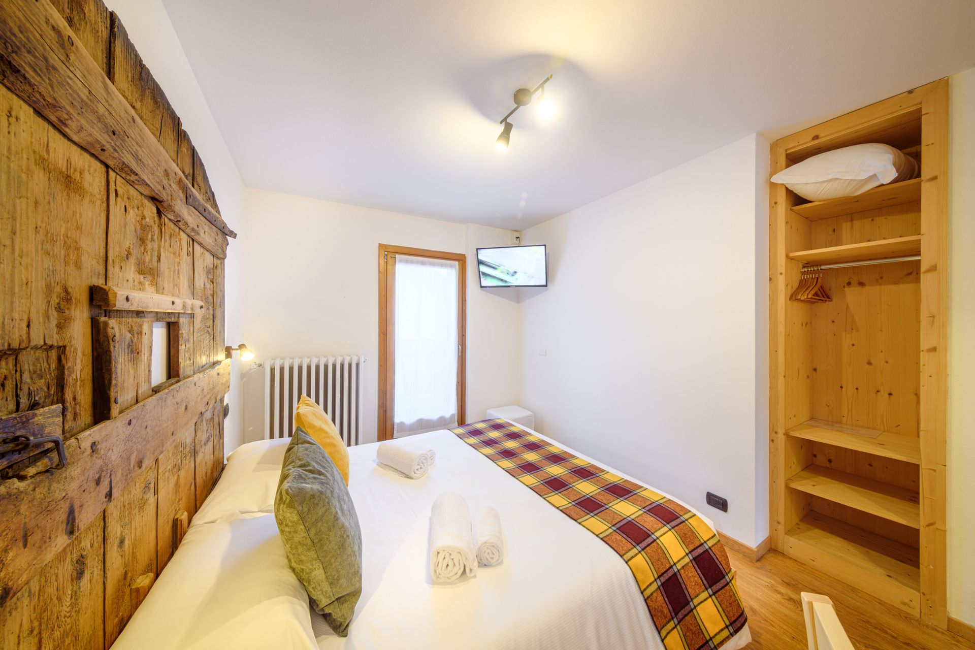 Accogliente camera da letto con parete decorativa in legno rustico, letto