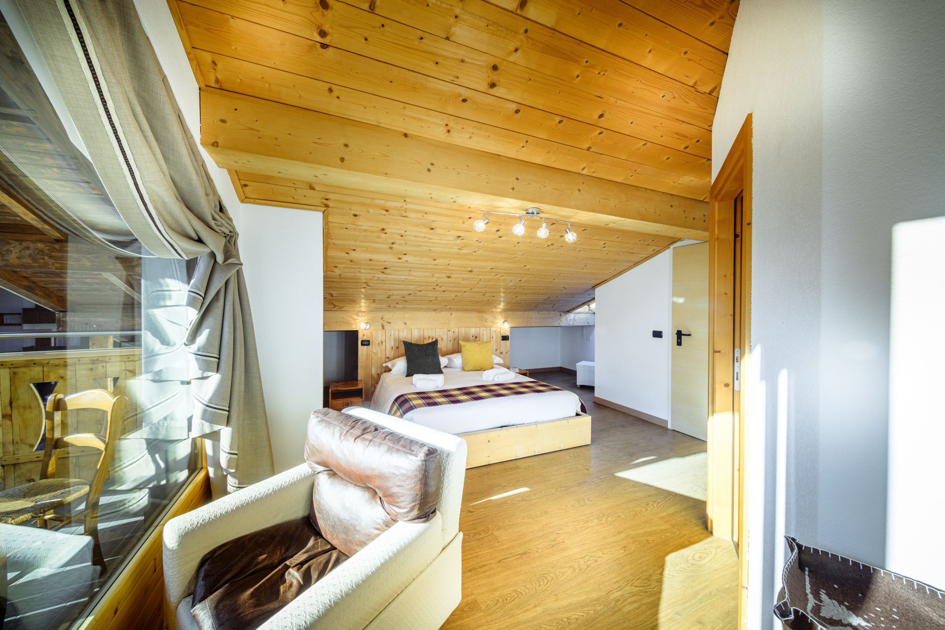Camera da letto in stile loft moderno con soffitto rivestito in legno